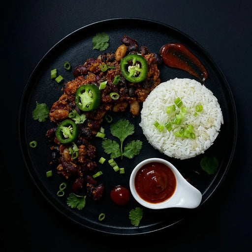 Plated dish with rice, meat, and vegetables on a dark background