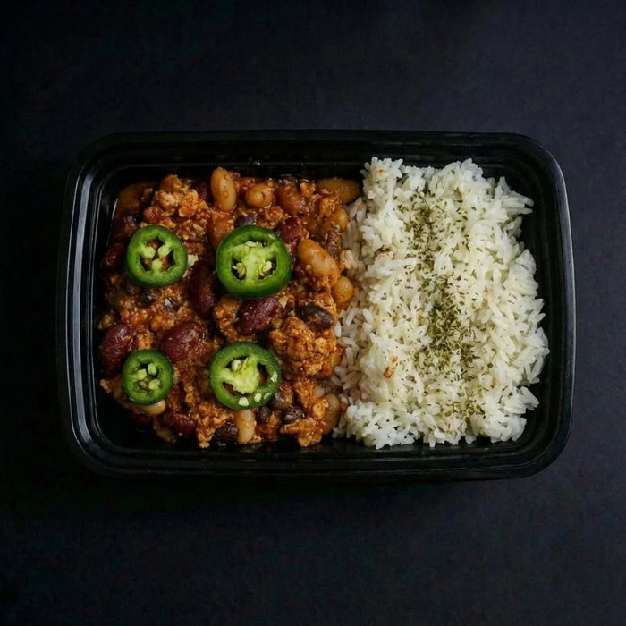 Black container with chili and rice on a dark background
