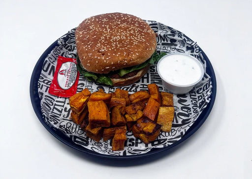 Burger with fries and a side of sauce on a patterned plate