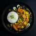 Plated dish of curry with vegetables and rice on a black background. The Halal Meal Preps