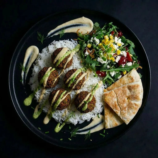 Plated dish with rice, falafel, salad, and pita bread on a dark background