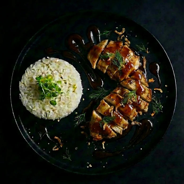 Plated dish of chicken with rice on a dark background