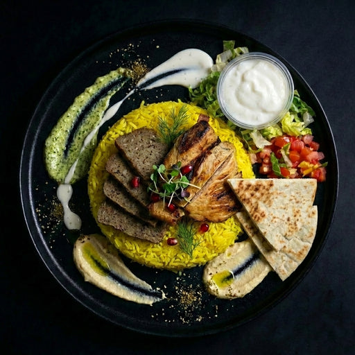 Plated dish with yellow rice, grilled meats, and vegetables on a dark background