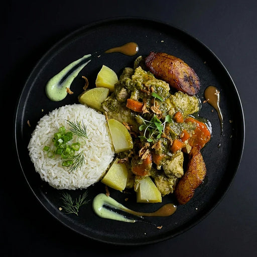 Plated dish with rice, vegetables, and greens on a black background