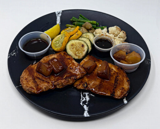 Plated dish with grilled meat, vegetables, and sauces on a black plate. A meal made by the halal meal prep.
