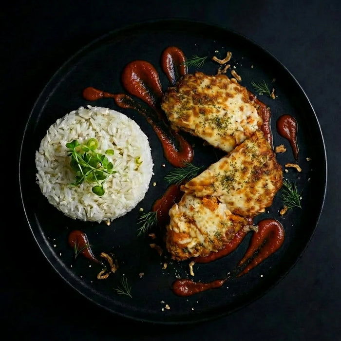 Plated dish with breaded chicken, rice, and ketchup on a dark background