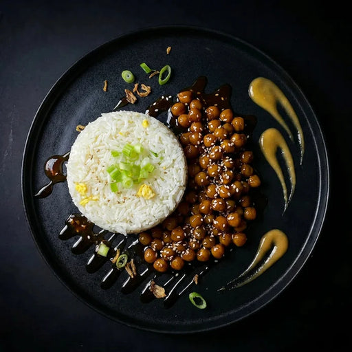 Plated dish with white rice, brown beans, and green onions on a dark background