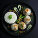 Plated dish with rice, meatballs, and vegetables on a dark background. The Halal Meal Preps