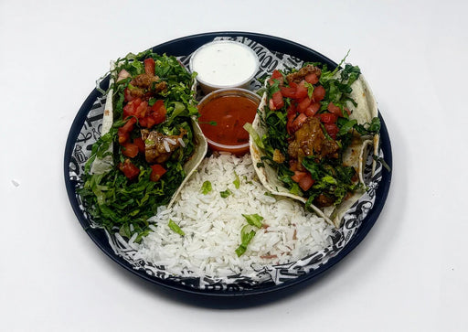 Plated meal with tacos, rice, and sides on a white background