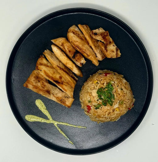 Plated dish with sliced bread and a ball of rice on a black plate.