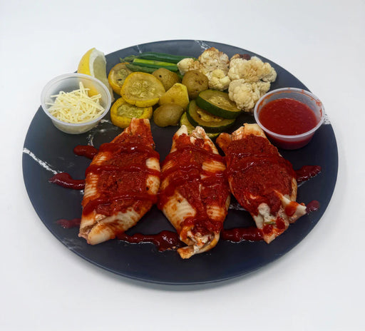 Plated dish with breaded and fried items, vegetables, and condiments on a white background